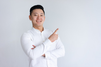 Positive asian man pointing finger aside Positive asian man pointing finger aside