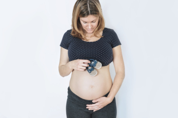 Pregnant woman concept with baby shoes