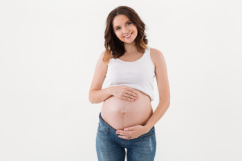 Pregnant woman standing isolated over white Free Photo