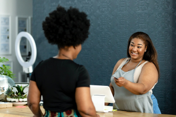 Receptionist taking payment for the customers | Free stock photo | High Resolution image