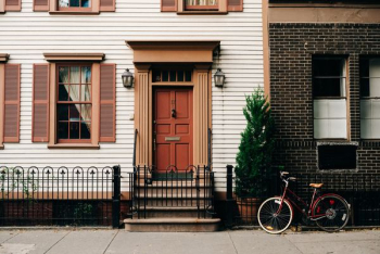 red bicycle parked beside black metal gate in front house red bicycle parked beside black metal gate in front house