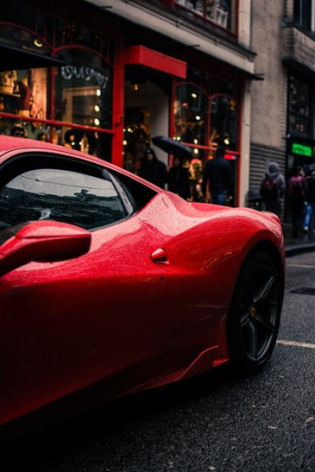 red car beside sidewalk red car beside sidewalk
