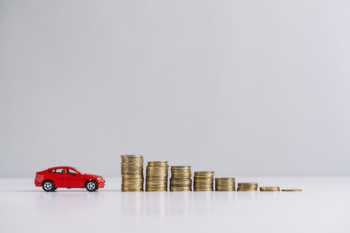 Red car near decreasing stacked coins Red car near decreasing stacked coins