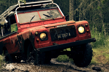 Red Car on Muddy Road Near Trees Red Car on Muddy Road Near Trees