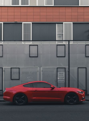 red Ford Mustang coupe parked beside the building red Ford Mustang coupe parked beside the building