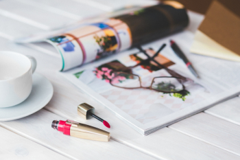 Red Lip Gloss and cup of coffee on white desk