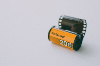 Roll of Kodak Gold Analogue Camera Film on a Light Blue Background Roll of Kodak Gold Analogue Camera Film on a Light Blue Background