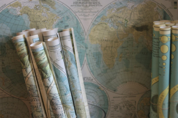 Rolled maps standing against a world | Free Photo - rawpixel