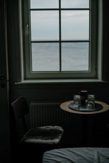 round brown wooden table near window round brown wooden table near window