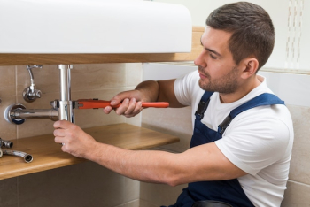 Sanitary technician using wrench on sink Sanitary technician using wrench on sink