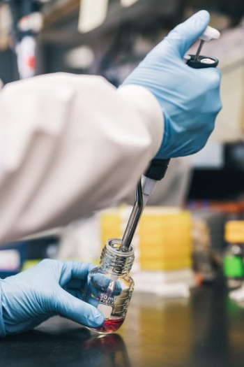Scientist Injecting Red Liquid Into Bottle Scientist Injecting Red Liquid Into Bottle
