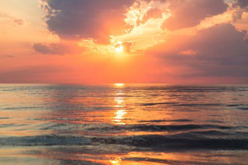 sea under white clouds at golden hour sea under white clouds at golden hour