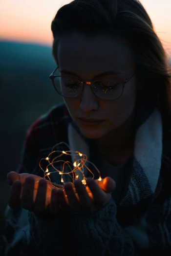 selective focus of woman holding light fixture at night