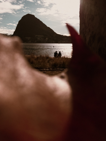Selective Focus Photo of People Sitting on Lakeside Selective Focus Photo of People Sitting on Lakeside