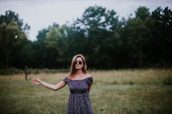 selective focus photo of woman standing on grass field selective focus photo of woman standing on grass field