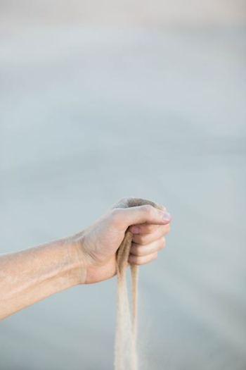 selective focus photography of person holding sand selective focus photography of person holding sand