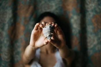 selective focus photography of woman showing conch shell selective focus photography of woman showing conch shell