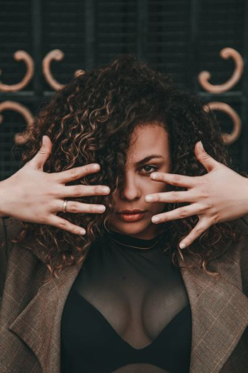 selective focus portrait photo of woman wearing brown suit jacket