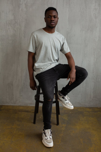 Self esteem young black male model sitting on chair in studio Self esteem young black male model sitting on chair in studio