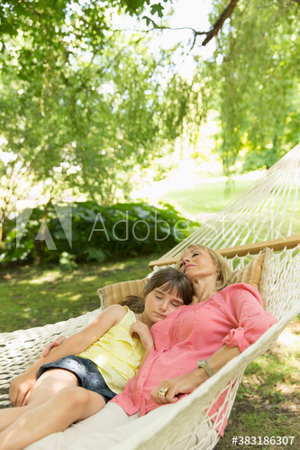 Serene grandmother and granddaughter relaxing in hammock Serene grandmother and granddaughter relaxing in hammock