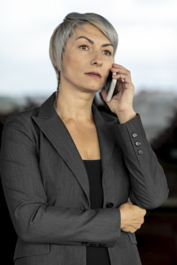 Serious buisness woman talking over phone Free Photo