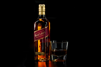 Shallow Focus Photo of Red Label Liquor Bottle Beside Drinking Glass Shallow Focus Photo of Red Label Liquor Bottle Beside Drinking Glass