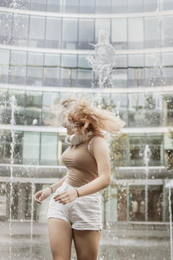 Shallow Focus Photo of Woman Standing Near Water Fountain Shallow Focus Photo of Woman Standing Near Water Fountain