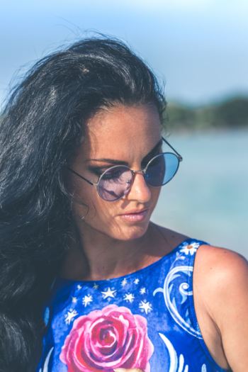Shallow Focus Photography of Woman Wearing Blue Floral Sleeveless Top and Black Sunglasses With Gray Frames