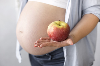 Side view pregnant woman holding an apple Free Photo