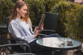 Side view smiley woman using tablet Free Photo