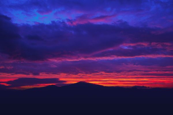 silhouette of mountain under cloudy sky during golden hour silhouette of mountain under cloudy sky during golden hour