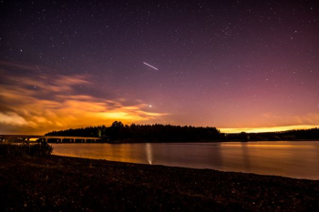 silhouette photo of island and falling star silhouette photo of island and falling star