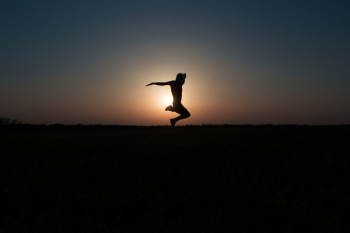 Silhouette Photo of Jumping Person during Twilight Hour