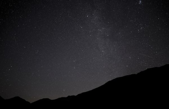 silhouette photo of mountain under star trail silhouette photo of mountain under star trail