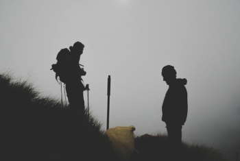 silhouette photo of two men climbing mountain silhouette photo of two men climbing mountain