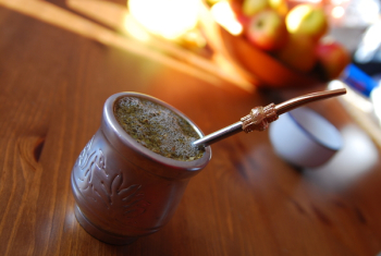 Silver-colored Teacup With Stirrer on Brown Wooden Table Silver-colored Teacup With Stirrer on Brown Wooden Table