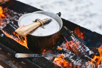 silver cook pot on firewood silver cook pot on firewood