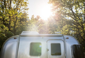 silver RV trailer near trees silver RV trailer near trees