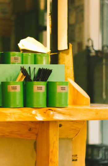 Six Green Tin Can Containers on Table Six Green Tin Can Containers on Table