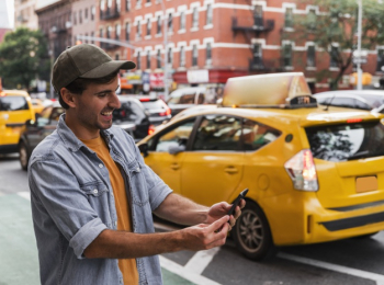 Smiley man in city holding mobile Free Photo