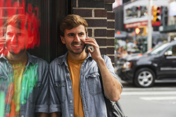 Smiley man talking at phone in city Free Photo