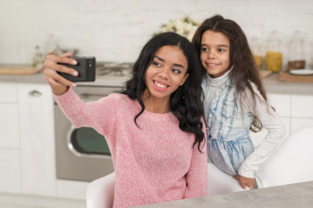 Smiley mom and daughter taking photos Free Photo