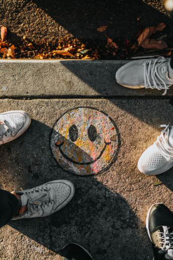 smiley paint on gray ground in front of people smiley paint on gray ground in front of people