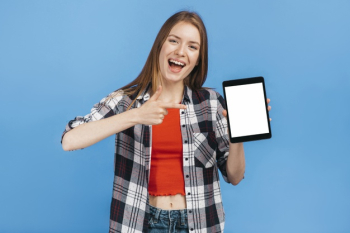 Smiley woman pointing to tablet mock-up Free Photo