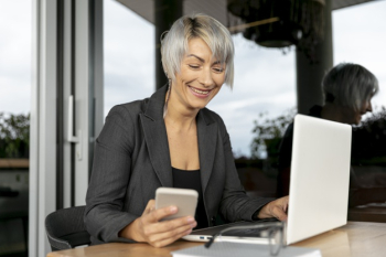 Smiley woman using electronic devices Free Photo