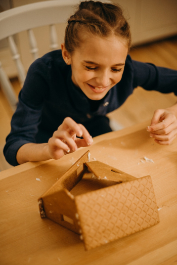 Smiling Girl Making House from Crackers Smiling Girl Making House from Crackers