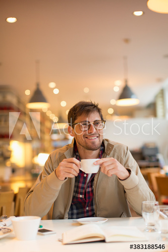 Smiling man drinking coffee in cafe Smiling man drinking coffee in cafe