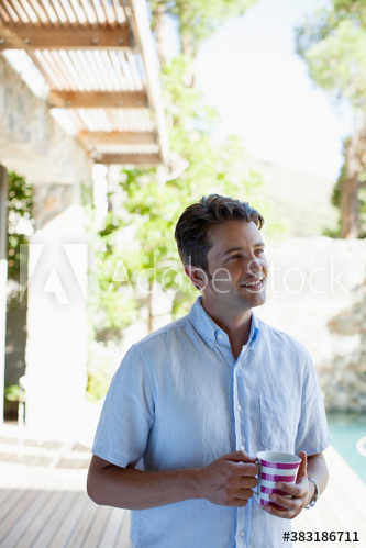 Smiling man drinking coffee on patio Smiling man drinking coffee on patio