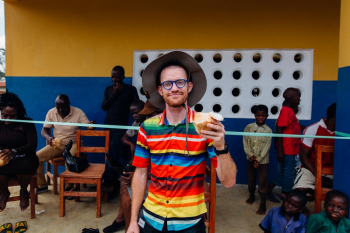 Smiling Man Holding Coconut Standing Near People Smiling Man Holding Coconut Standing Near People