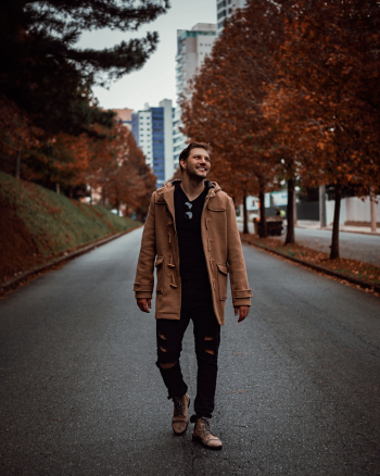 Smiling Man Walking Alone on Pathway